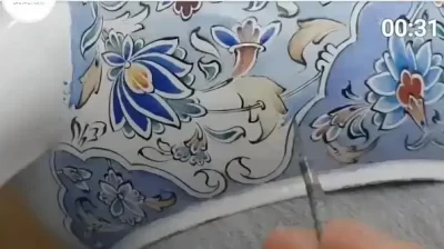 رنگ آمیزی و قلم گیری در میناکاری یکی از مراحل ساخت ظروف میناکاری