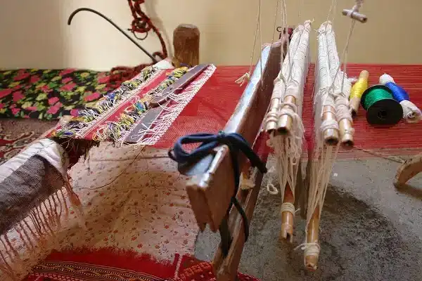 تصویری از هنر ابریشم بافی در خراسان شمالی، شامل شال و روسری های دست باف با نخ های رنگارنگ و لطیف که اصالت جاده ابریشم را یادآور می شود.