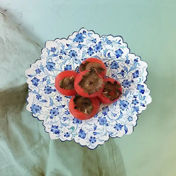 بشقاب میناکاری دست ساز با خرمالوهای تازه داخل آن، ترکیب زیبایی از هنر ایرانی و طبیعت