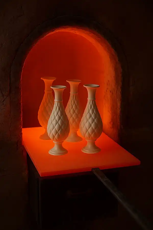 نمای داخلی یک کوره داغ با آثار میناکاری در حال پخت و تثبیت رنگ